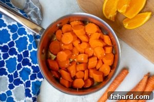 Quick & Sweet Glazed Carrots 10 Pan with cooked carrots with garlic, next to oranges