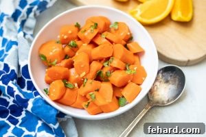 Quick & Sweet Glazed Carrots 11 Bowl of Glazed Carrots next to fresh orange slices.