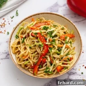 Cold noodle salad in bowl topped with sesame seeds.