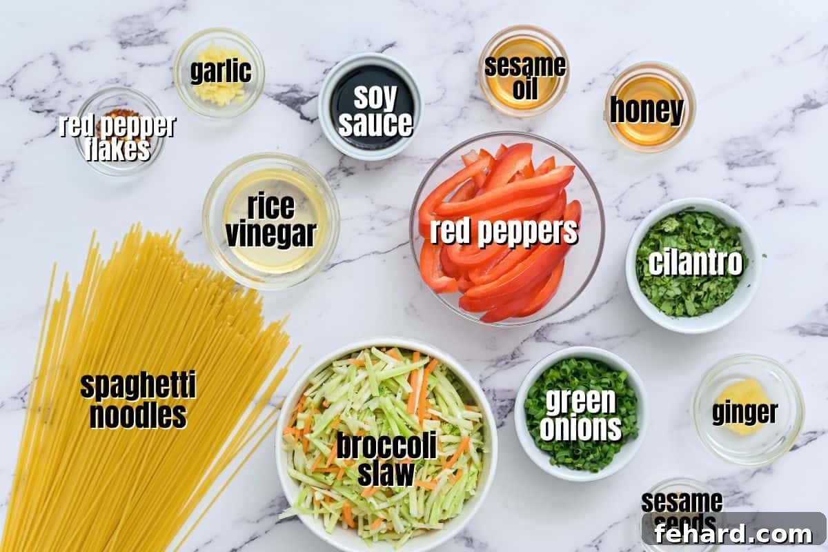 Cold Asian Noodle Salad Ingredients A flat lay image showing all the fresh ingredients laid out on a kitchen counter: noodles, various chopped vegetables, and dressing components.