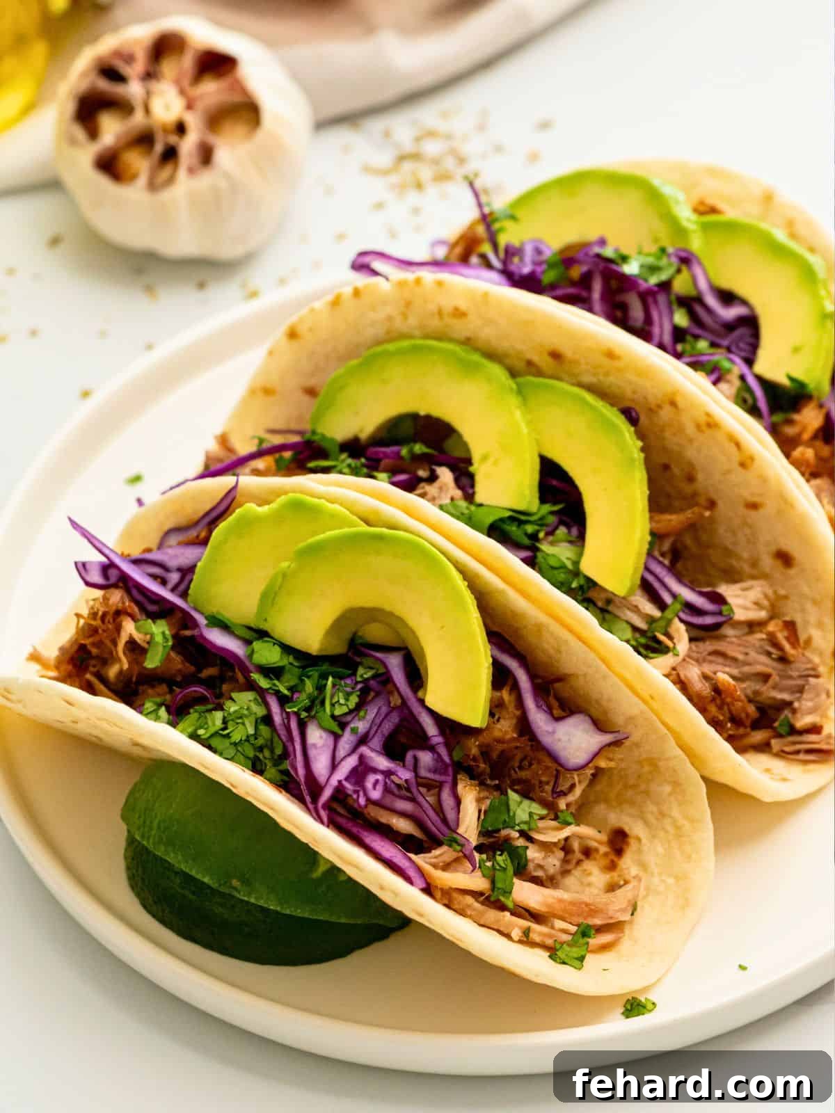 Instant Pot Carnitas Instant Pot shredded pork served on flour tortillas with cabbage, lime juice, and avocado.