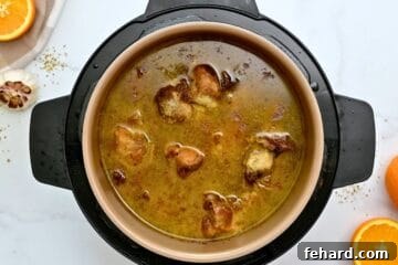 Pressure cooked pork roast in beer and orange juice inside inner pot.