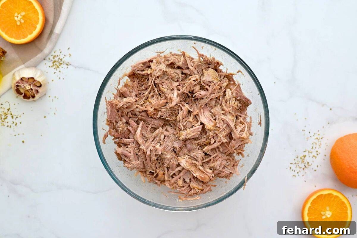 Easy Pork Tacos Instant Pot Pressure cooked pork taco meat shredded in mixing bowl.
