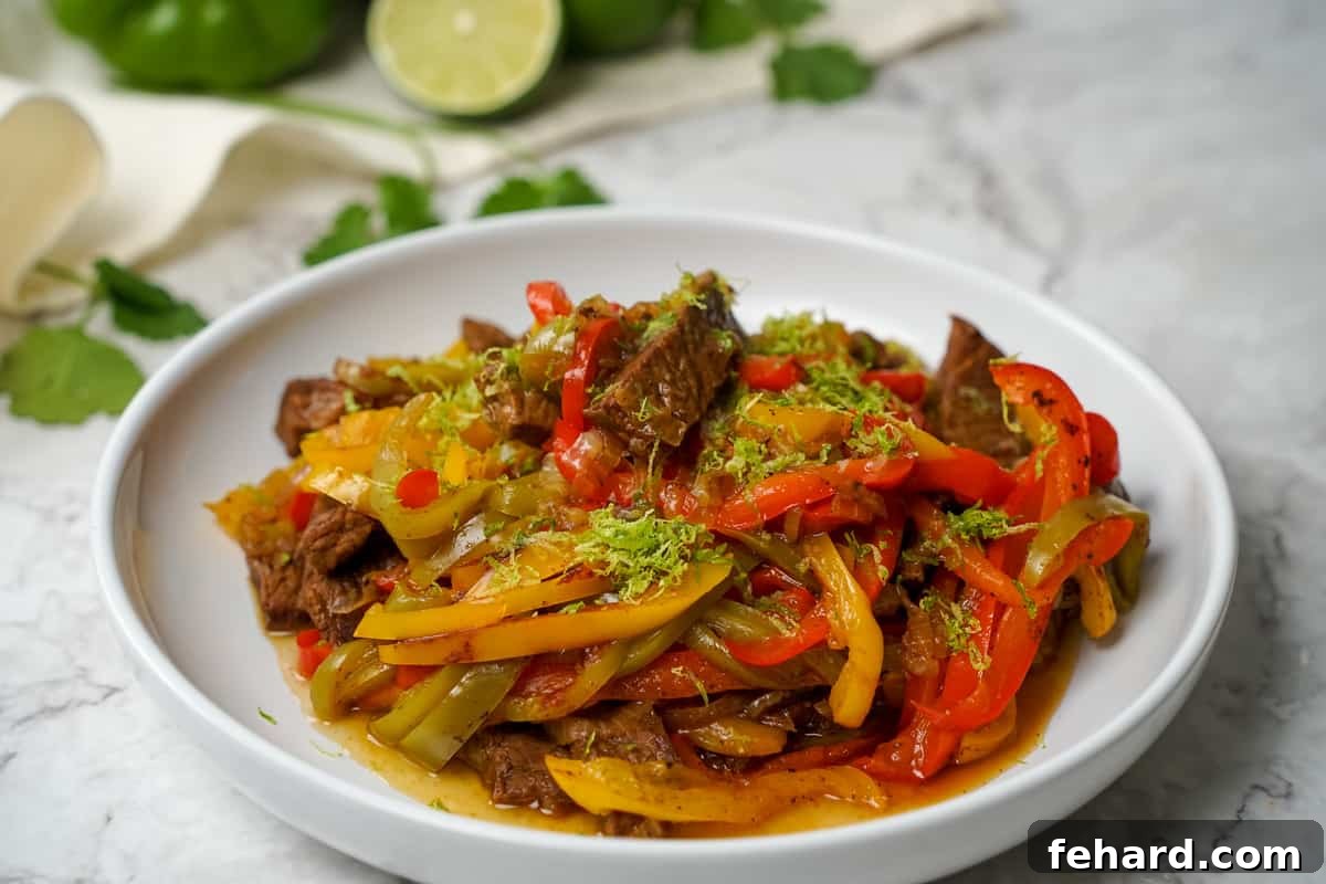 Instant Pot Fajita mixture topped with lime zest on platter. Ready to serve fajitas with a fresh lime garnish.