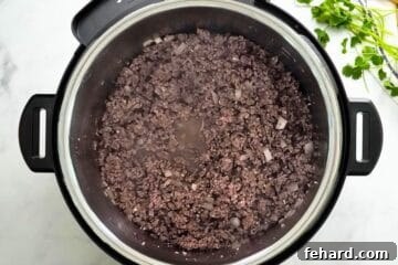 Ground beef and onion sauteed inside Instant Pot.