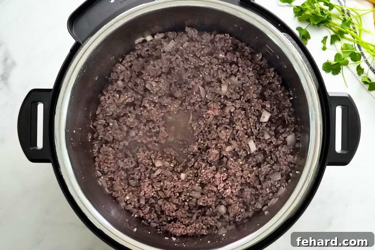 Sautéing Beef and Onions for Instant Pot Chili Ground beef and onion sauteed inside Instant Pot.