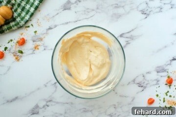Cream Cheese and sour cream mixed together with taco seasoning in mixing bowl.