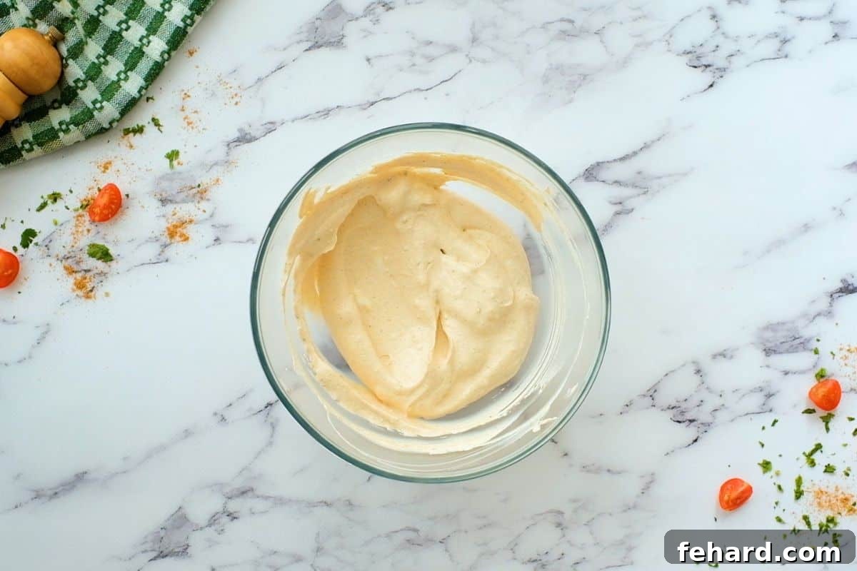 Cream Cheese, sour cream, and taco seasoning blended in a mixing bowl.