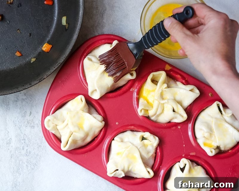 Mini Muffin Tin Quiches being brushed with egg wash