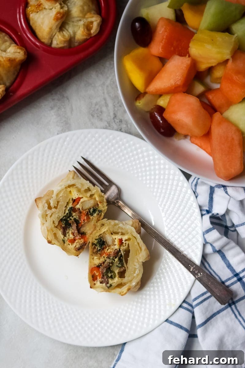 Puff pastry quiche cut open with eggs, bacon, peppers and spinach.