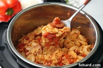 Spoonful scooping out jambalaya out of instant pot.