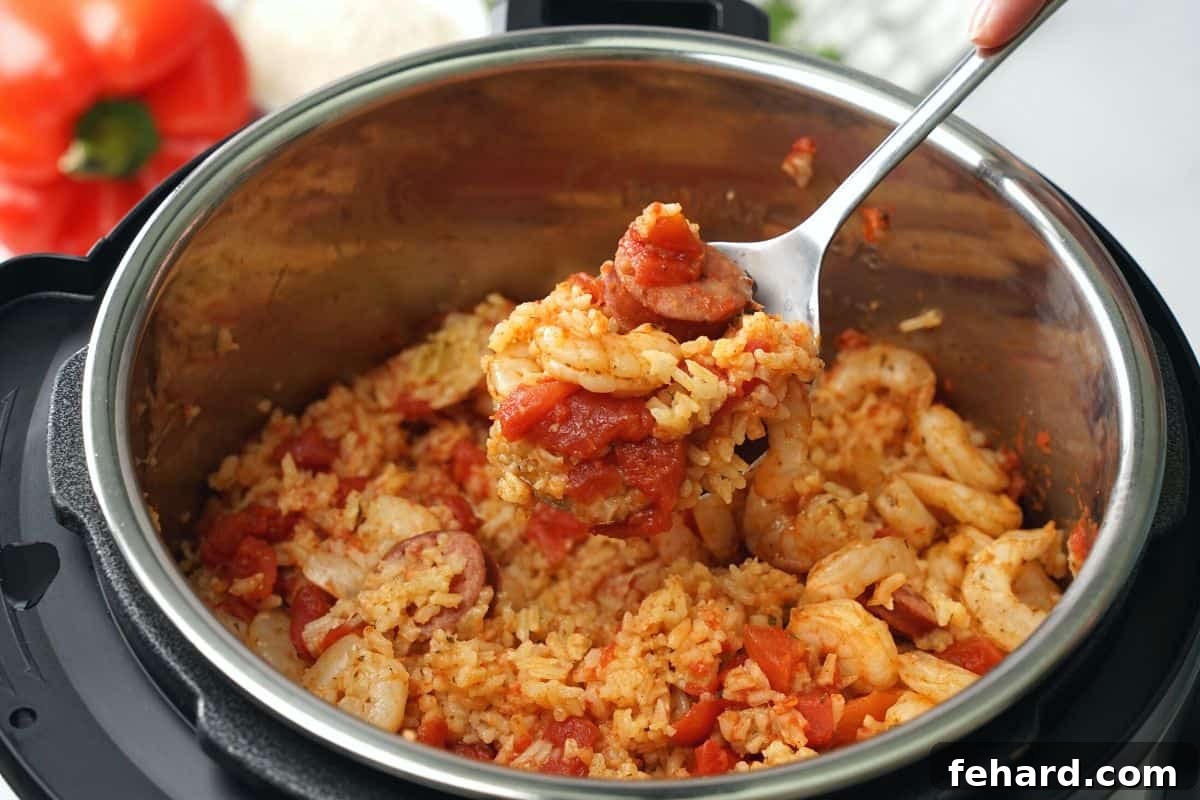 Easy Instant Pot Cajun Jambalaya Spoonful scooping out jambalaya out of instant pot.