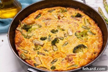 Baked Asparagus Frittata in a cast iron skillet, golden and set.