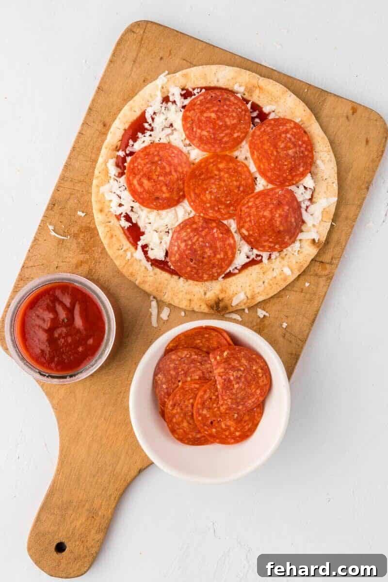A classic assembled Pita Pizza featuring melted cheese, savory pizza sauce, and slices of pepperoni, freshly baked and delicious.