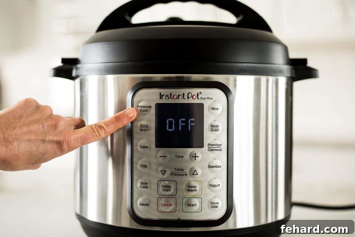 Mastering Instant Pot Cook Modes with Manual Pressure Cook Finger pointing to the Pressure Cook button on an Instant Pot control panel.