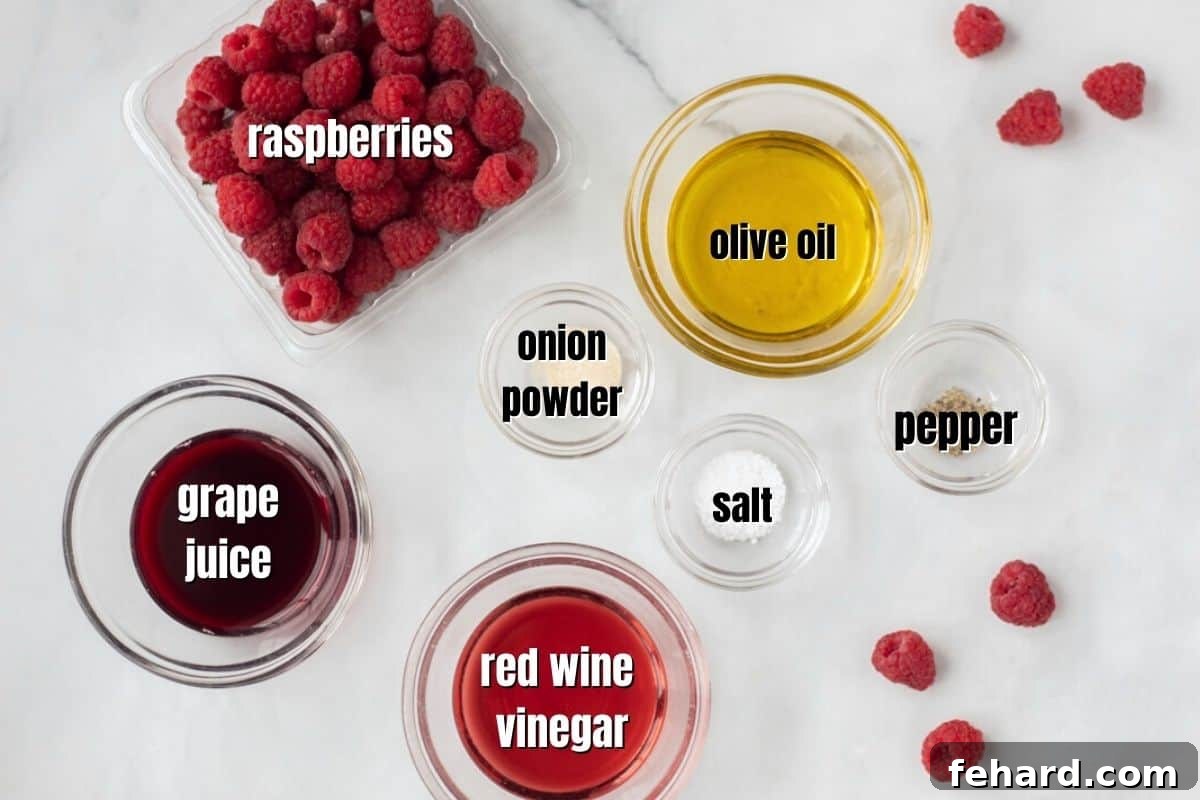 Ingredients for fresh raspberry salad dressing arranged on a counter.