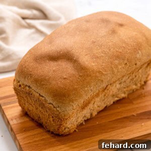 Loaf of wheat bread on cutting board.