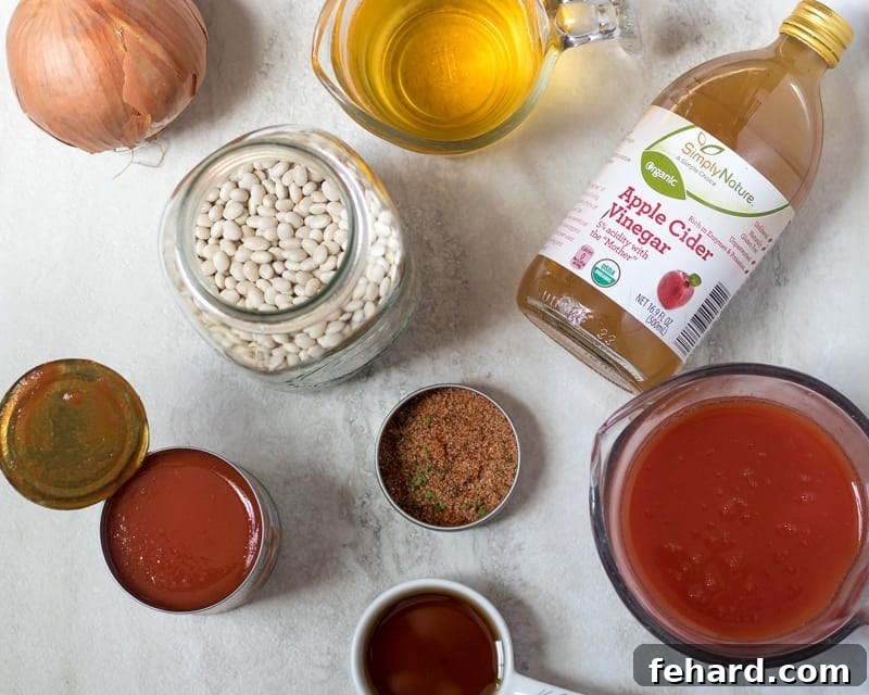 Instant Pot Baked Beans Ingredients Ingredients for Instant Pot Baked Beans laid out on a white kitchen counter, including beans, bacon, onion, and various sauces and spices.