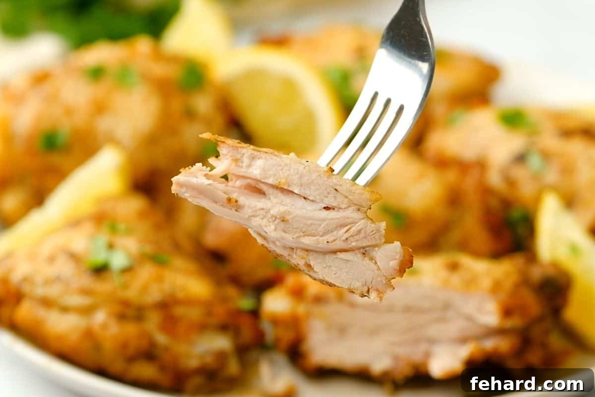 A fork presenting a succulent bite of perfectly cooked, juicy Instant Pot chicken thigh, highlighting its tender texture and appetizing appearance.