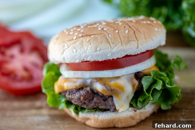 Instant Pot Burgers Result in Boiled Meat A delicious burger on a bun, topped with fresh tomato, onion, and lettuce, with sliced tomatoes visible in the background.