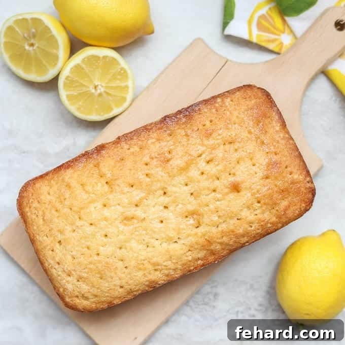 Baking Bread in Instant Pot Yields Dense Results A freshly baked loaf of Lemon Bread resting on a rustic wooden cutting board.
