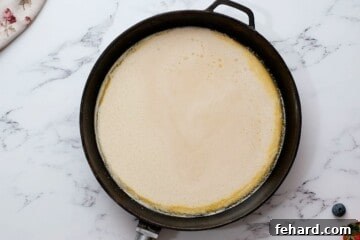 Batter for Dutch Oven Pancake poured into a hot, greased skillet.