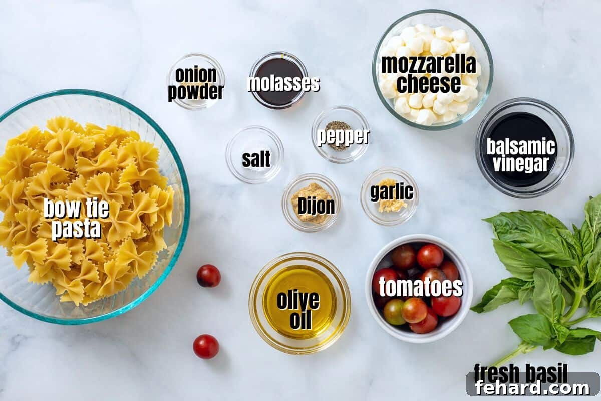 A flat lay image showing all the fresh ingredients for Caprese Pasta Salad: various pasta shapes, grape tomatoes, mozzarella balls, a bundle of fresh basil, and a small bowl of balsamic dressing.