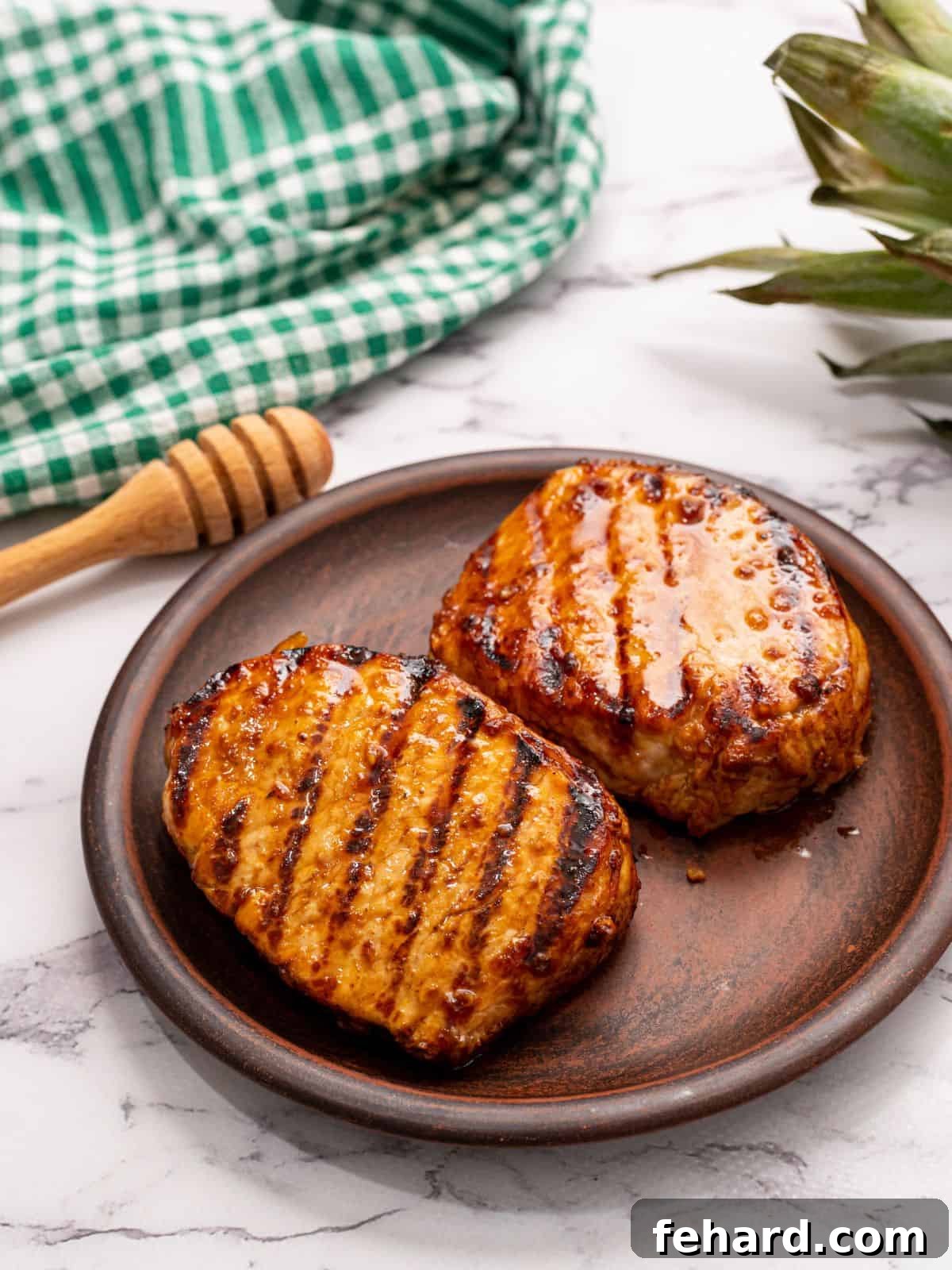 Irresistible Honey Garlic Pork Chops Honey Garlic Pork Chops on wooden plate next to fresh pineapple, highlighting their juicy texture.