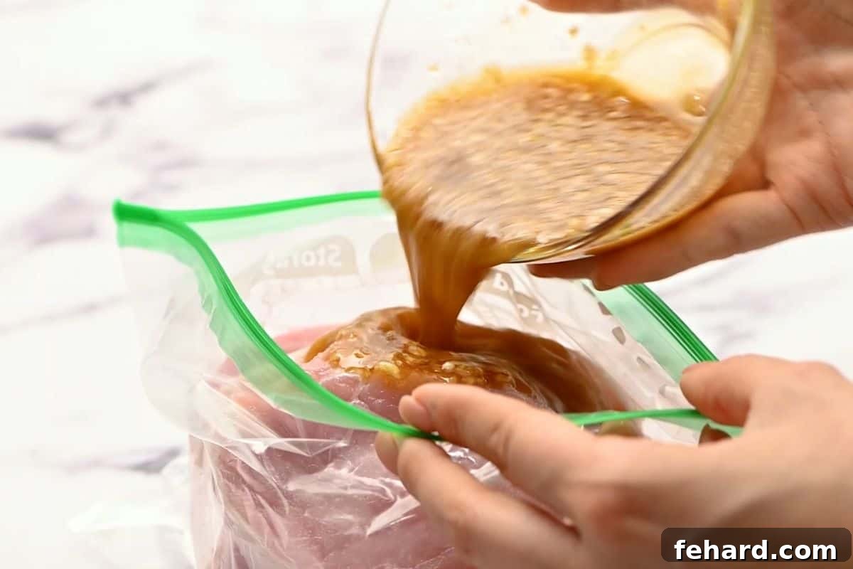 Honey Garlic Pork Chop Marinade Marinade pouring over pork chops in a freezer bag, ensuring even coating.