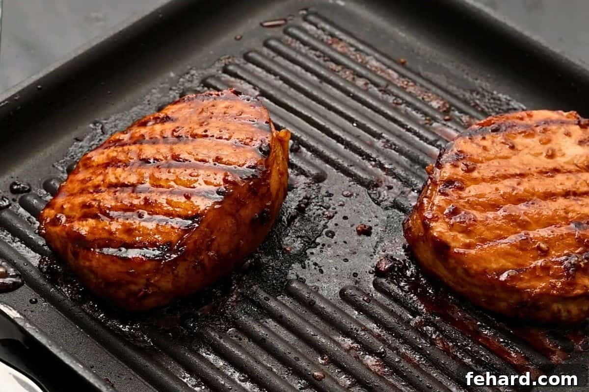 Perfectly Cooked Honey Garlic Pork Chops Marinated pork chops resting on a grill plate after cooking to 145 degrees F, ready to be served.