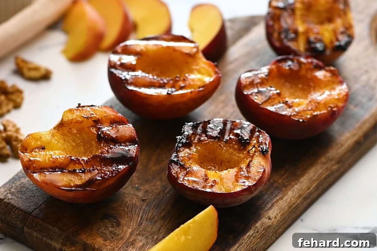 How to Grill Peaches for an Easy Summer Dessert Cinnamon sugar grilled peaches on wooden cutting board, ready to be served with a fork.