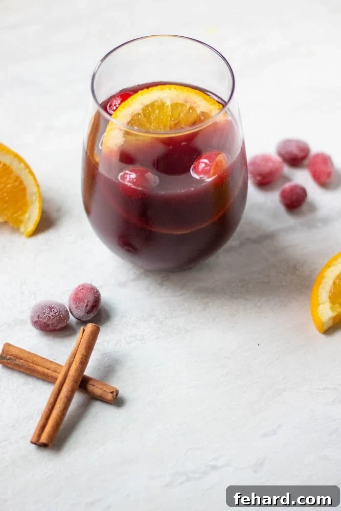 Mulled Wine Recipe - Perfect for the Holidays Glass of mulled wine with oranges and cranberries, ready to be served