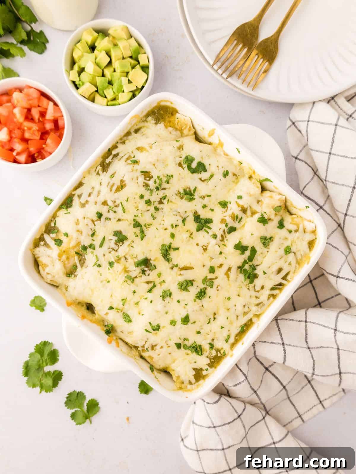 Freshly baked Chicken Salsa Verde Enchiladas, golden and bubbling in a white baking dish, elegantly garnished with finely minced cilantro, showcasing their delicious readiness.