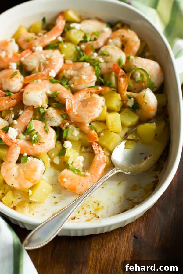 Roasted potato halves generously topped with succulent lemon shrimp, served in an elegant baking dish.