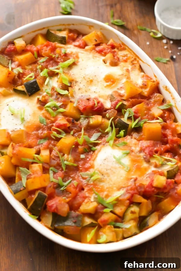A close-up view of the baked eggs with veggies casserole, showing the perfectly cooked eggs with golden yolks among the soft, colorful vegetables, ready to be scooped and enjoyed.