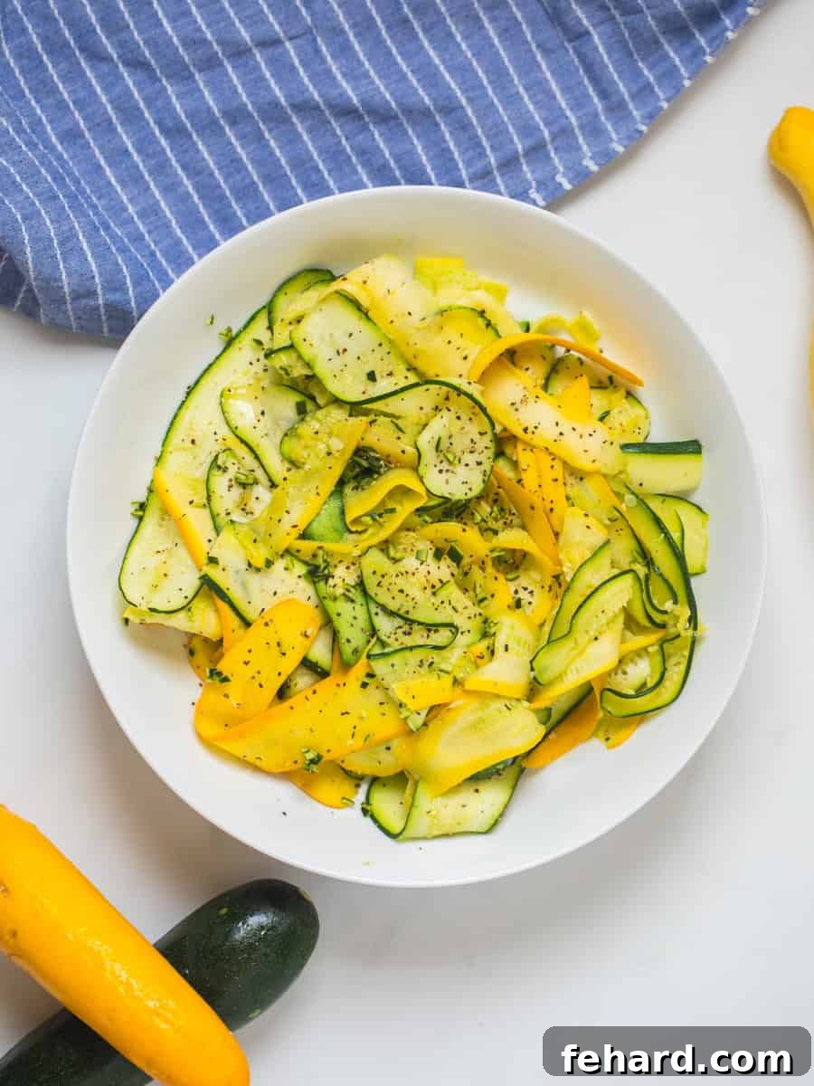 Easy Sauteed Zucchini and Yellow Squash Recipe Beautiful ribbons of vibrant green zucchini and golden yellow squash elegantly arranged in a white serving bowl, garnished with freshly chopped parsley, ready to be enjoyed.