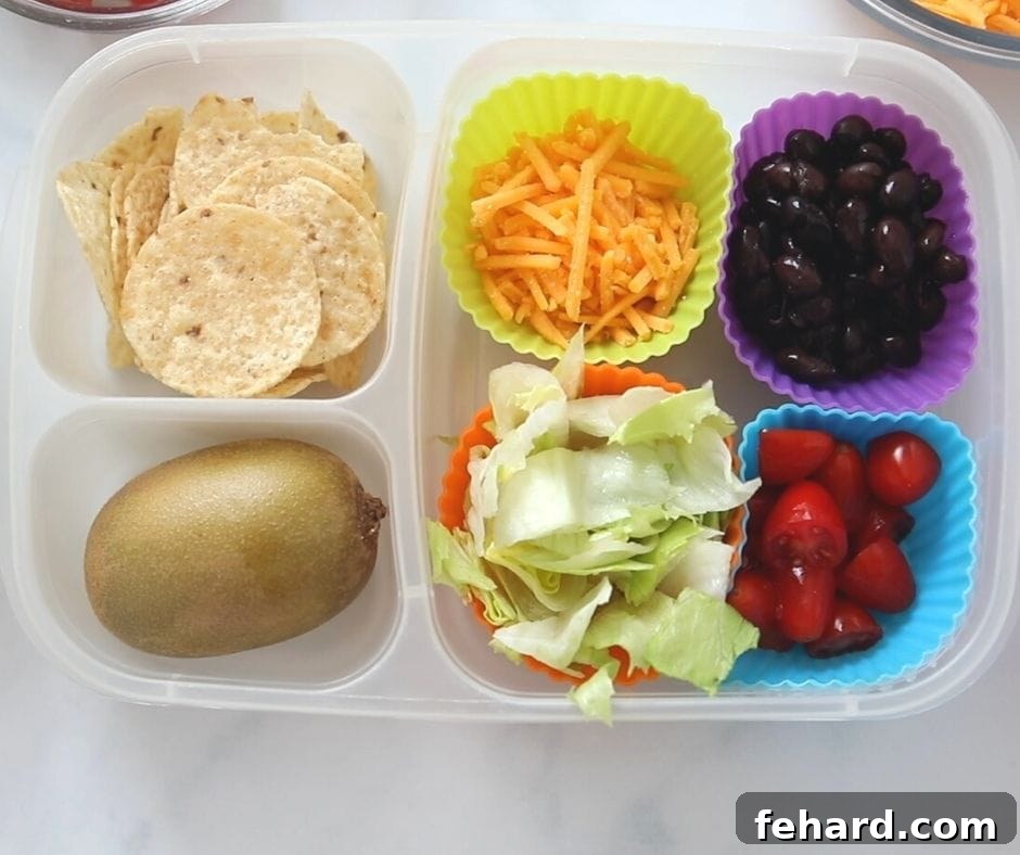 Easy Nut-Free Lunch Idea: Build-Your-Own Nachos Ingredients for a deconstructed taco salad in a lunch container, featuring beans, cheese, and fresh veggies.