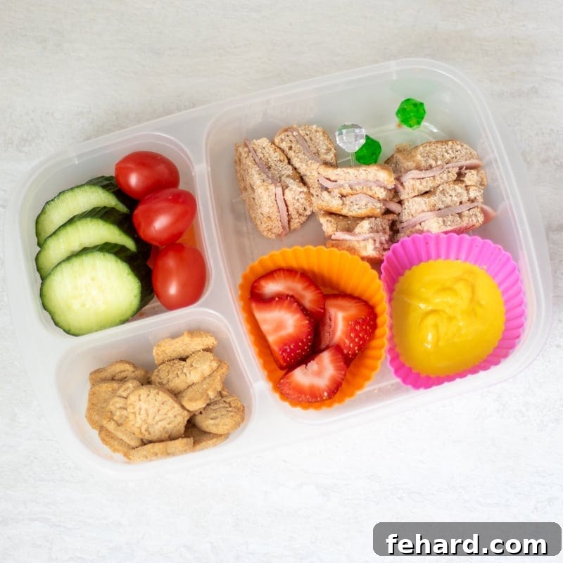 Nut-Free Homemade Lunchable: Skewered Fun Ham and Cheese on Skewers in a lunch box with vegetables, strawberries, and animal crackers.