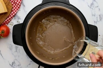 Water being poured into the instant pot after sauteeing the beef.