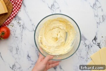Ricotta cheese in mixing bowl with seasonings, eggs, and cheese.