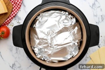 Assembled Lasagna inside inner pot covered with foil.