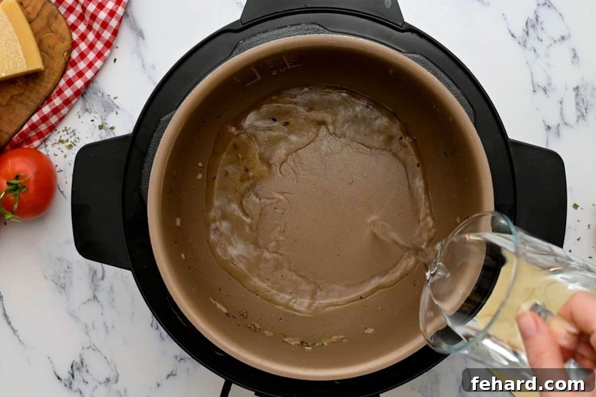 Water being poured into the Instant Pot inner pot after sautéing, ready for deglazing.