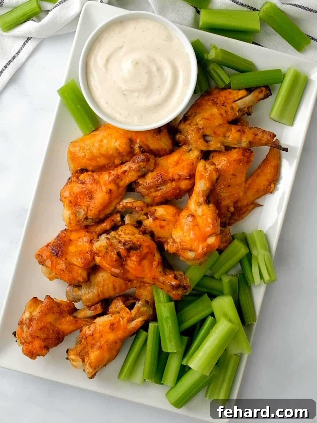 Instant Pot Chicken Wings on white platter with celery.