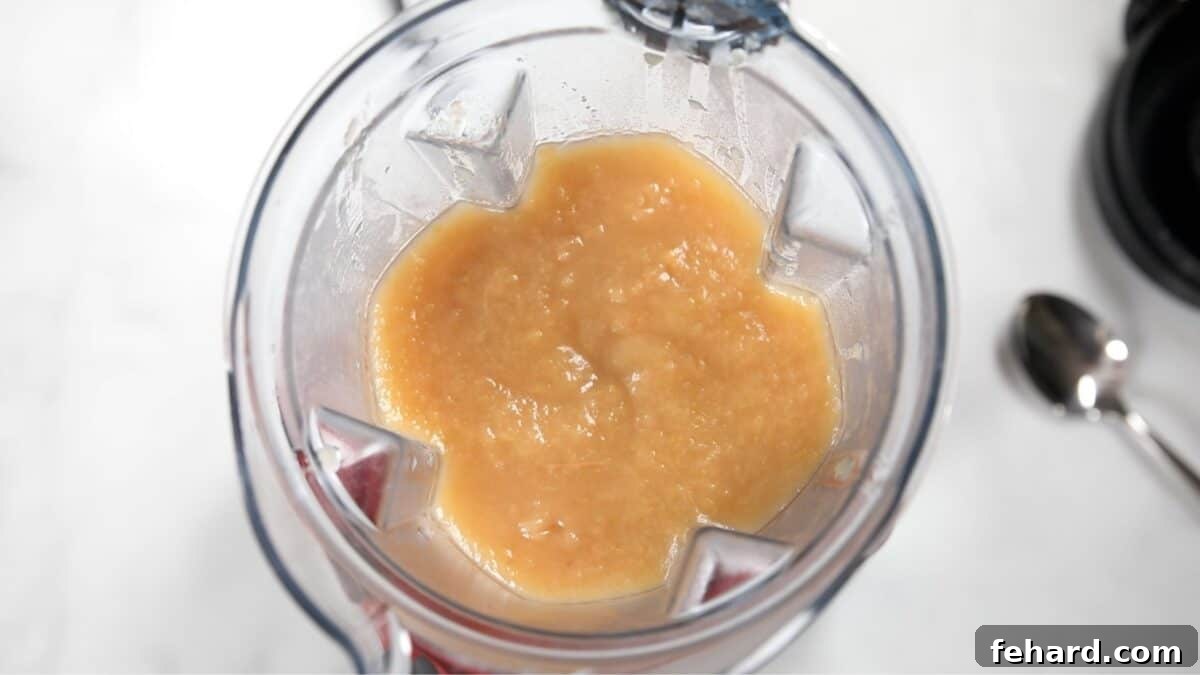 Farmhouse Apple Sauce 2 Smooth, perfectly blended applesauce swirling within a high-speed blender, indicating it's reached the desired silky consistency and is ready to be served.