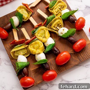 Antipasto Skewers with tomatoes and mozzarella on wooden cutting board ready to be served.