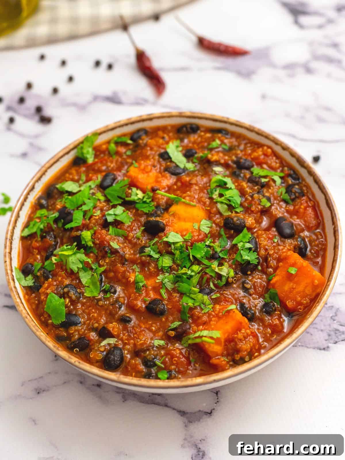 Sweet Potato Black Bean Chili: The Ultimate Healthy Vegan Recipe A vibrant bowl of sweet potato black bean chili, generously topped with fresh, minced cilantro, highlighting the rich textures and colors of this wholesome meal.