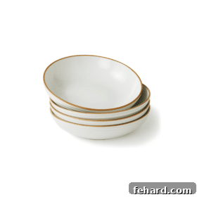 A stack of beautifully designed white pasta bowls with a distinct hand-painted edge, perfect for serving culinary creations.
