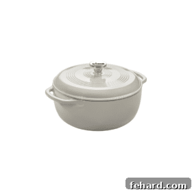 A pristine white cast iron Dutch oven with a lid, a versatile essential for slow cooking and baking.