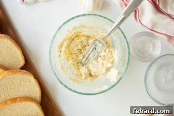 Garlic Butter mashed together in bowl with fork and thick bread to the side.