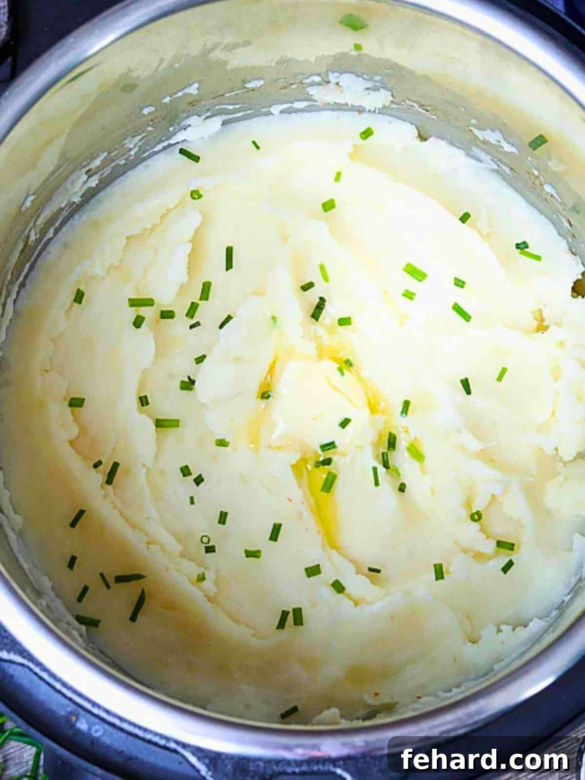 Inner Pot filled with creamy mashed potatoes topped with butter and chives, ready to serve.
